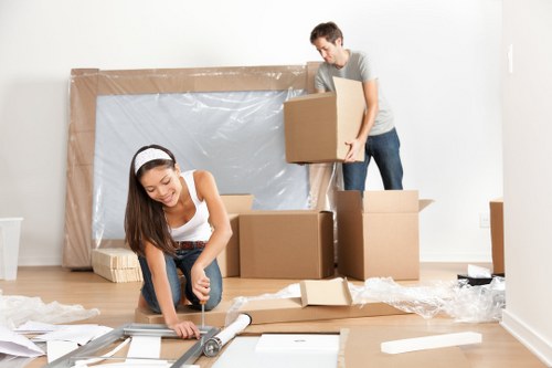 Students moving boxes and furniture in Romford residential area